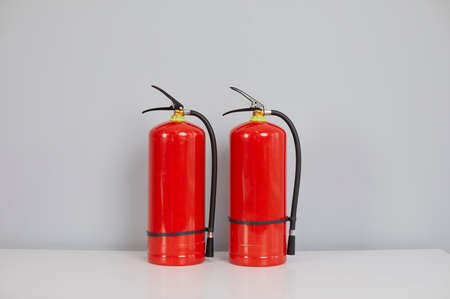 Two red standard fire extinguishers inside the building. Chemical, carbon dioxide or air pressurized...