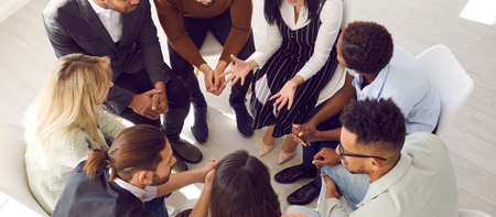 People sitting in circle share problems during psychological rehabilitation session. Top view of...