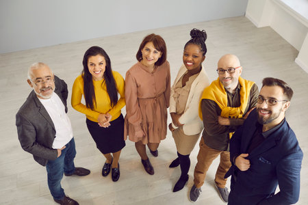 Top view portrait of smiling diverse multiethnic employees look at camera pose in office together. Happy multiracial businesspeople show unity and leadership at workplace. Diversity and teamwork.の写真素材