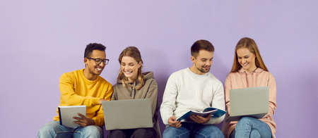 Student friends prepare for the lecture together with the help of gadgets and notebooks. Multiracial...