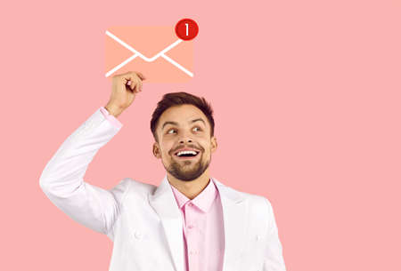 Happy handsome man holding envelope icon with red notification about new message. Cheerful...
