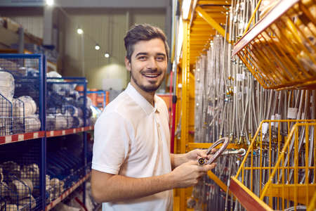 Male customer shopping at a modern DIY store. Portrait of a happy man standing in the aisle and...