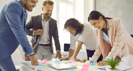Happy business team having fun in work meeting. Group of positive cheerful people standing at office...