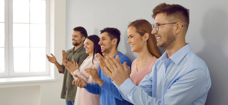 Banner narrow shot of overjoyed diverse businesspeople applaud show appreciation and acknowledgement. Smiling employees clap hands greeting or congratulating with promotion.の写真素材