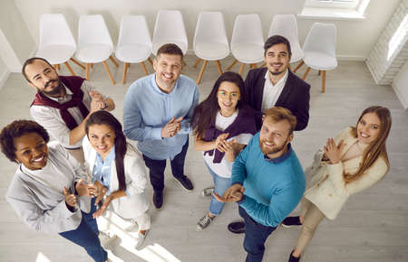 Diverse team of happy business people standing together and applauding. Group portrait of young male...
