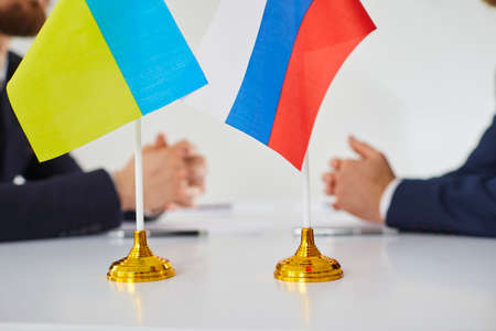 Close up of Russian and Ukrainian flags. Diplomats negotiate on war between Russia and Ukraine. International relations. Conflict settlement and negotiations. Diplomacy. Stop war.の写真素材