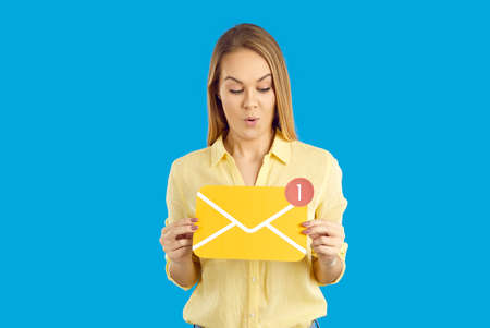 Surprised teen girl hold envelope with unread message sign on social media or mail. Stunned young...