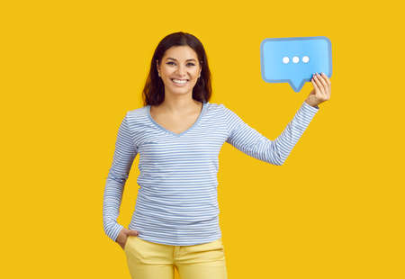 Portrait of happy joyful confident beautiful woman in casual clothes standing on yellow color studio...