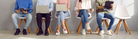 Group of business people using laptops and tablets. Several male and female candidates using...
