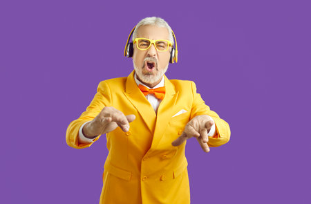 Cheerful senior gray-haired mustache bearded man in elegant yellow blazer with bow tie and stylish...