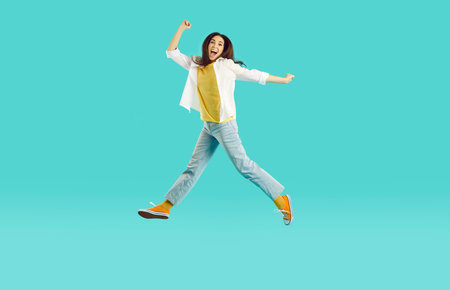 Yay. Happy pretty woman having fun in comfortable wear. Full length portrait excited ecstatic crazy...