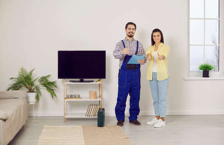 Portrait of smiling repairman and woman customer show thumbs up give recommendation. Happy mechanic...