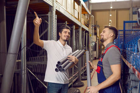 Man in building materials store consults with seller on account of plastic pipes for plumbing....