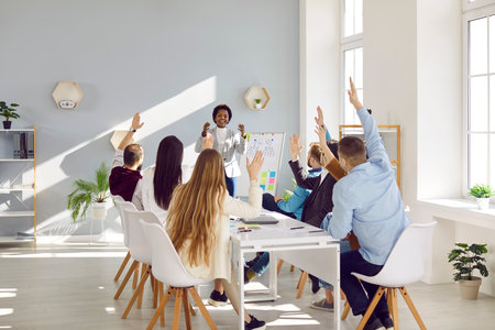 African american businesswoman manager stands in front of clipboard and diverse business people sitting around the table, raising hands, voting at corporate meetingの写真素材