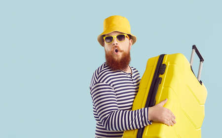 Funny ginger guy goes on vacation. Plus size man in bucket hat, sunglasses and striped swimwear...