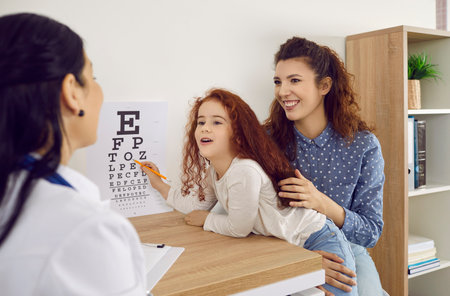 Concept vision testing. Mother with little daughter checks her childs vision at ophthalmology...