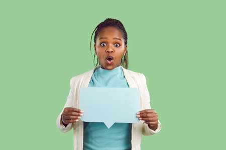 Black woman holding mock up copyspace speech bubble on color studio background. Afro American lady...