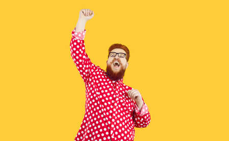 Funny chubby man celebrating achieving his goal. Happy lucky crazy fat plus size ginger man in polka...