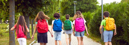 Children on their way to school. Group of little kids going to class. Six male and female students...