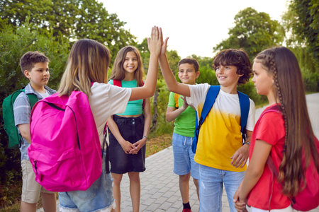 Group of school children having fun in the park. Cheerful little friends playing games outdoors....