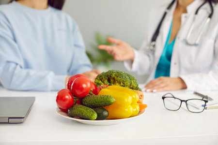 Fresh healthy vegetables in plate cucumbers, tomatoes and bell peppers containing vitamins on table of nutritionist doctor symbolize benefits of proper nutrition and vegetarianism. Selective focusの写真素材