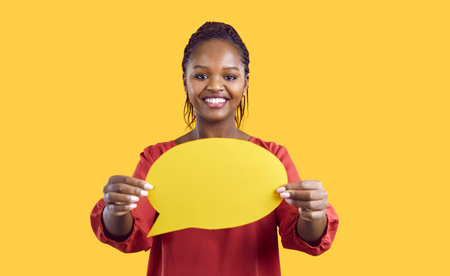 People and communication. Paper blank mockup of speech bubble in hands of smiling african american...