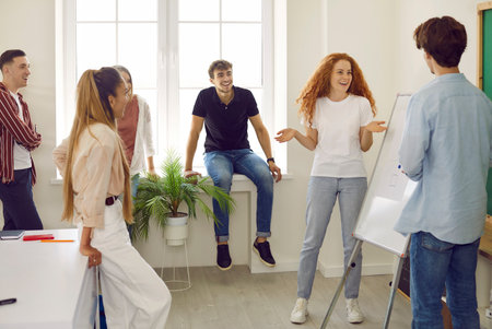 Breaktime in college. Group of college students are having fun and casual conversation together in...