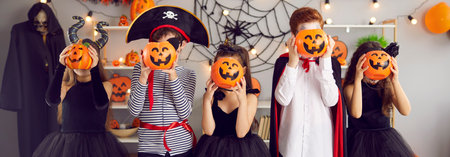 Narrow web banner shot of cute small children dressed in costumes for Halloween celebration have fun...