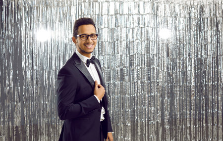 Portrait of attractive and elegant showman or host of festive event on silver shiny background....