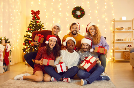 Group portrait of happy young friends who celebrate New Year holidays together at home. Multiracial...