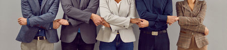 Team of young diverse multiethnic people in suits standing in row all together and holding hands. Business team, teamwork, corporate unity concept. Cropped shot. Banner backgroundの写真素材