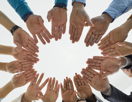 Creative team folds their hands together. Diverse people form circle of hands demonstrating...