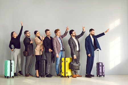 Group of people with suitcases going on business trips or holidays, standing in line at the airport, waving hands, and saying goodbye to their friends and family. Traveling by plane conceptの写真素材