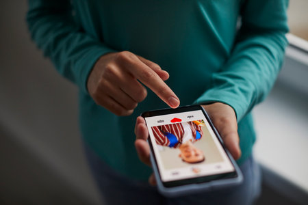 Dating online. Close-up of person using mobile phone for internet use. Young man holds his finger on...