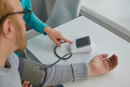 Nurse or doctor uses a tonometer to measure the blood pressure of a senior man patient with hypertension. Medicine, high pressure, old age, medical check-up, and treatment conceptsの写真素材