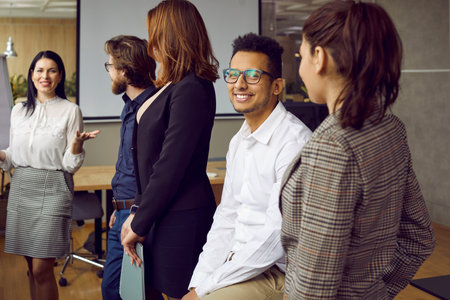 Diverse multiracial people brainstorm discuss ideas at team meeting in office. Smiling multiethnic colleague talk collaborate at briefing. Teamwork and cooperation. Diversity concept.の写真素材