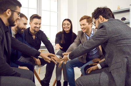 Beautiful men and women join hands in circle as symbol of cooperation and unity. Young, happy...