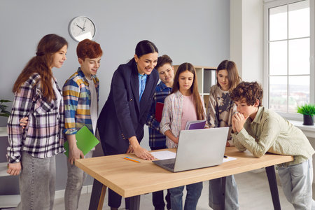 Group of junior high school students and classmates standing in the classroom near their friendly...