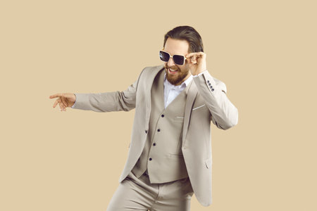 Happy man in formal suit having fun in fashion studio. Cheerful joyful carefree young businessman...