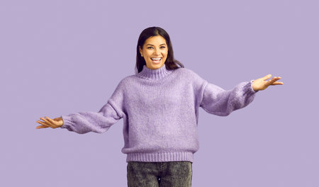 Happy attractive young ethnic woman looks at camera with smile happily telling you good news spreads...