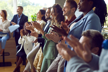 Group of happy joyful business people applaudding to speaker standing in a row in meeting room....