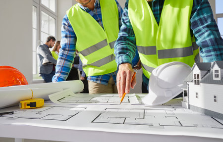 Construction engineers, architects or builders meeting in office and discussing blueprint plans....