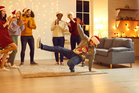 Happy young multiethnic people having fun at Christmas party in beautiful modern studio apartment....