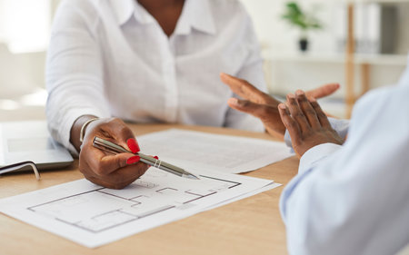 Close up cropped portrait of interior designer african american woman showing her client floor plan...