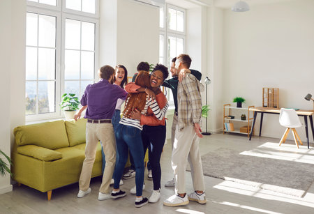 Young people diverse group, student community meeting, happy friends team giving hug of comfort, reassurance, emotional support, parting after college graduation, volunteering club eventの写真素材