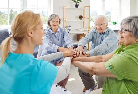 Senior people and care assistant team high five play in retirement home old age home nursing...
