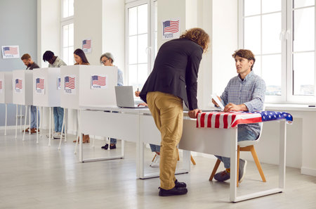 Back view portrait american man with long hair registering at polling station with American flags on...
