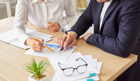 Office business team of male, female employees meeting, analyzing project document text, reports, marketing charts notes, planning new work process, discussing papers, doing paperwork report analysisの写真素材