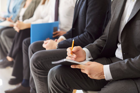 Close up group of formal wear smart people office lobby chair row sitting, working with documents, writing, fixing, worker arrangement meet, hr candidates waiting for business interview, consultationの写真素材