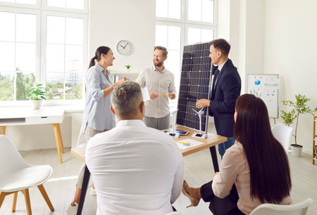 Office team participates in a group presentation focused on solar panels and renewable energy. The discussion highlights alternative power sources and the importance of sustainable energy solutions.の写真素材